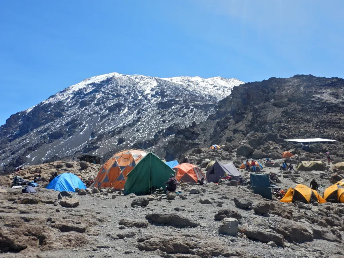 Tents at Barafu Camp below the snowy summit cone, a sight on Kilimanjaro climbing tours