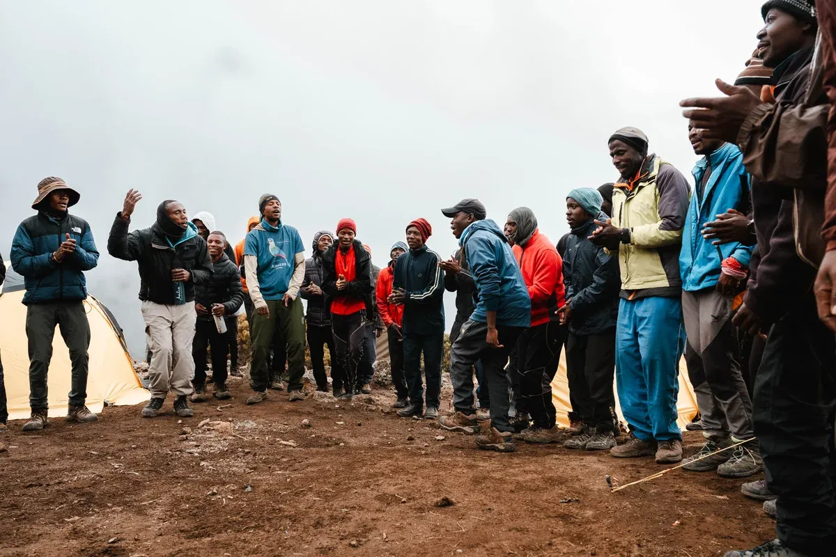 Porters singing at a high camp, a sight on Kilimanjaro climbing tours